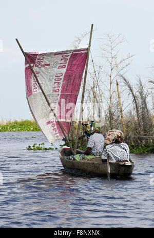 Le donne da Ganvié villaggio di pescatori in una piccola imbarcazione a vela Lago Nokwe, Benin Foto Stock