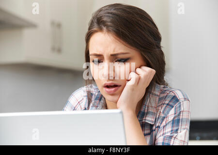 Ragazza adolescente vittima di bullismo online con il computer portatile Foto Stock