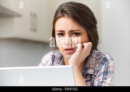 Ragazza adolescente vittima di bullismo online con il computer portatile Foto Stock