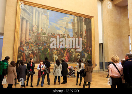 I visitatori del museo del Louvre a Parigi in Francia in piedi di fronte ad un banchetto di nozze di Cana dal tardo-rinascimentale manierista o I Foto Stock