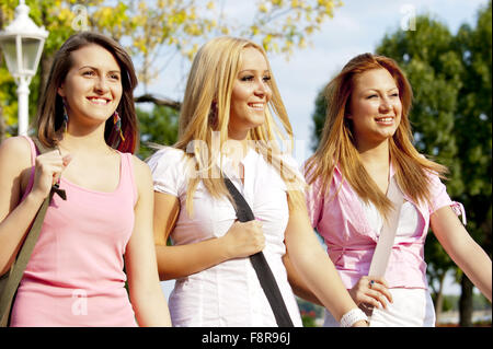 Felice giovani studenti di scuola superiore o gollege ragazze sorridenti andare a scuola a piedi attraverso il parco Foto Stock