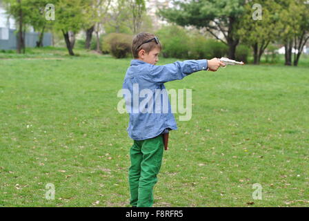 Ragazzo giocando con una pistola giocattolo Foto Stock
