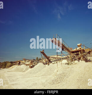 Nastri trasportatori e macchinari in una cava di ghiaia shot in una limpida giornata di sole shot con inclinazione e spostamento lente Foto Stock