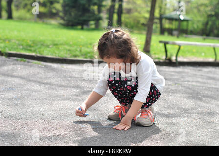 Disegno ragazza campana sulla strada con Chalk Foto Stock