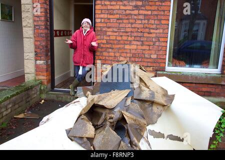 Carlisle, Cumbria, Regno Unito. Undicesimo Dec, 2015. Meteo e dei danni provocati dalle inondazioni. Donna in piedi con la sua alluvione mobili danneggiati. Tempesta Desmond causato gravi inondazioni in Carlisle e in Cumbria. Carlisle, Cumbria, Inghilterra, Regno Unito. Credito: Andrew Findlay/Alamy Live News Foto Stock