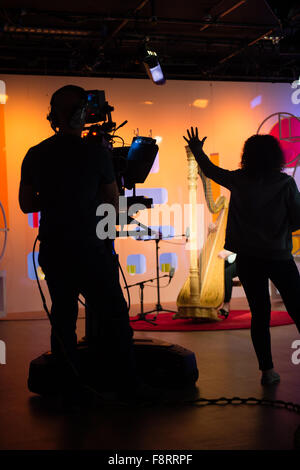 Un cameraman e femmina piano studio manager al lavoro durante la trasmissione di un programma TV dal vivo su welsh canale TV S4C da studi di 'Heno' nell'Tinoplis media center, Llanelli, Galles del Sud Foto Stock