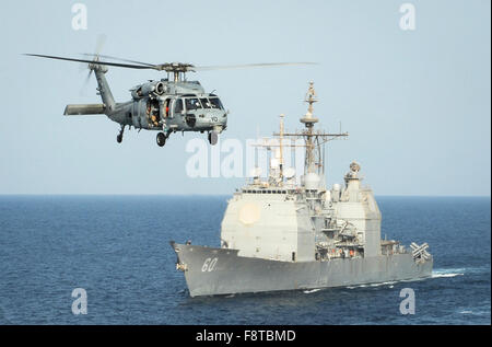 HH-60H Sea Hawk elicottero assegnato al mare Cavalieri del Mare in elicottero Combat Squadron (HSC) 22 passa il guidato-missili cruiser USS Normandy Foto Stock