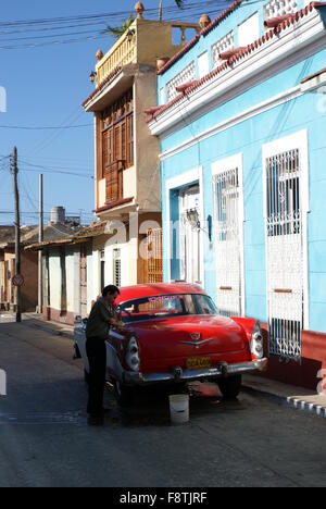 L'uomo il lavaggio auto in strada, Trinidad, Cuba Foto Stock