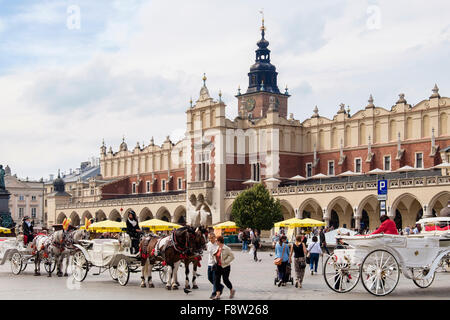 City tour carrozze trainate da cavalli al di fuori del XIII secolo Sukiennice (panno Hall o trasportatori' Hall) nella Piazza del Mercato di Cracovia in Polonia Foto Stock