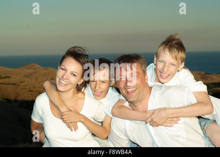 La famiglia felice nel campo di grano Foto Stock