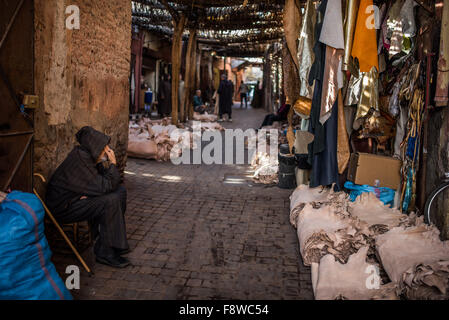 Il vecchio uomo marocchino pelli si faccia. Pelli cuoio in attesa di essere tinti e trasformato in negozio di souvenir in vendita nei souk di Marrakech Foto Stock