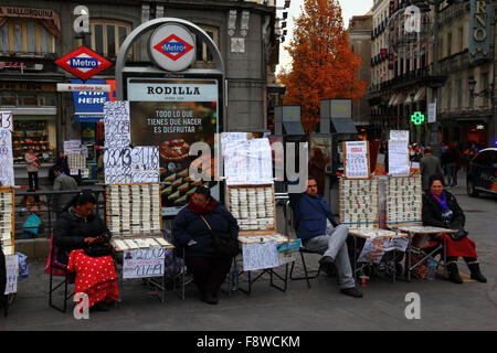 Madrid, Spagna 11 dicembre 2015: Venditori di biglietti della lotteria che vendono biglietti per la lotteria di Natale accanto ad un ingresso alla stazione della metropolitana Sol in Plaza Puerta del Sol nel centro di Madrid. La lotteria di Natale spagnola è una delle più antiche al mondo e la più grande al mondo in termini di pagamento totale. Il biglietto vincente è noto come "El Gordo" ("il grande" o "il grasso"). Crediti: James Brunker / Alamy Live News Foto Stock