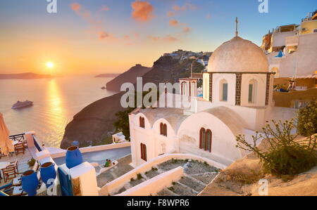 Thira (città capitale di Santorini) - Paesaggio con greca chiesa bianca e il tramonto sul mare - Santorini Island, Grecia Foto Stock