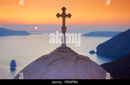 Santorini, Grecia - Vista in chiesa con la croce in cima al tramonto a Thira (città capitale di Santorini) Foto Stock