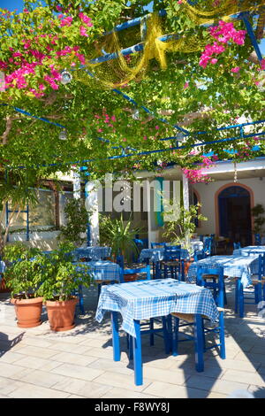 Ristorante locale decorato con fiori - villaggio di Kamari, isola di Santorini, Cicladi, Grecia Foto Stock