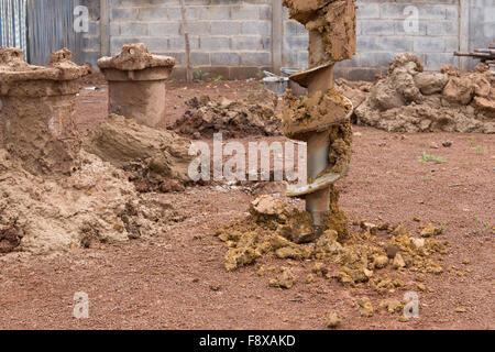 Macchina per la perforazione di fori nel terreno al sito in costruzione Foto Stock