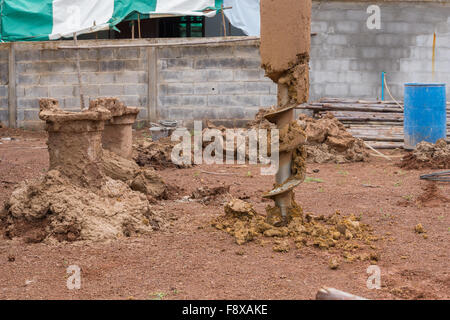 Macchina per la perforazione di fori nel terreno al sito in costruzione Foto Stock