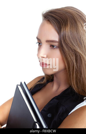 Una giovane donna allegra studente tenendo i libri e guardando lontano Foto Stock