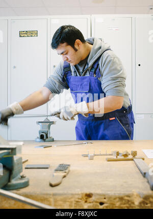 Dresden, Germania. Decimo Dec, 2015. Profugo afgano Sha Kah Ahmadi file di pezzi di metallo al Fortbildungsakademie der Wirtschaft training academy di Dresda, in Germania, 10 dicembre 2015. L'Accademia dispone attualmente di due rifugiati sul lavoro, prove per valutare le loro competenze. Foto: OLIVER KILLIG/DPA/Alamy Live News Foto Stock