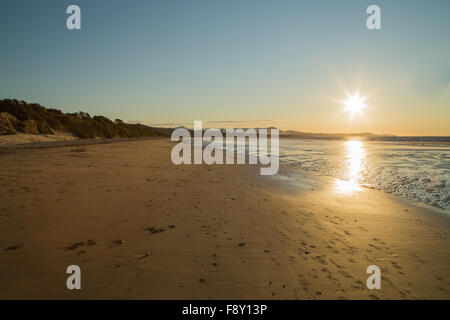 Arancio e blu cielo durante il tramonto sulla spiaggia con riflessi di luce Foto Stock