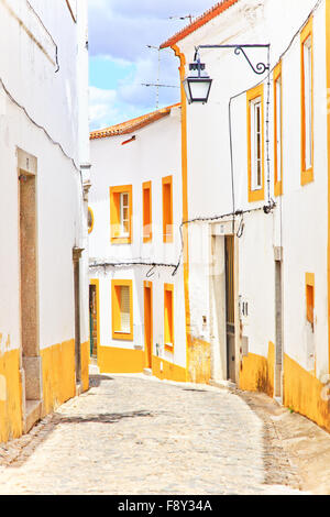 Vecchia strada urbana nella città di Evora. Le facciate bianche e colorate di windows. Alentejo, del Portogallo, dell'Europa. Foto Stock