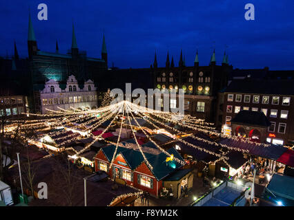 Lubecca, Germania. Decimo Dec, 2015. Visitatori passeggiata attraverso gli illuminati mercatino di Natale di fronte al municipio di Lubecca, Germania, 10 dicembre 2015. Foto: Daniel Bockwoldt/dpa/Alamy Live News Foto Stock