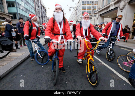 BMX motociclisti vestiti da Babbo Natale corsa giù per Oxford Street Foto Stock