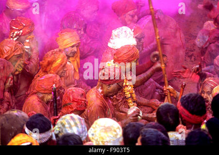 Persone intonacato in acqua colorata, cantare un inno in movimento verso un tempio durante "Holi festival" a Mathura, Uttar Pradesh, India. Foto Stock