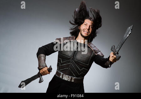 Il cavaliere arrabbiato con la spada contro uno sfondo scuro Foto Stock