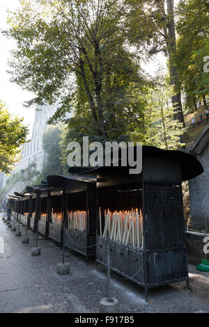 Fila di brulières pieno di candele devozionali presso la grotta di Massabielle nel Santuario di Nostra Signora di Lourdes Foto Stock