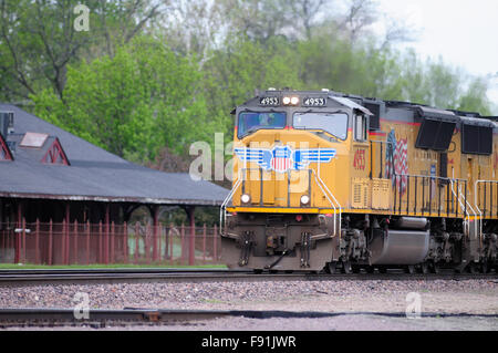 Un treno merci in uscita da Chicago è guidato da un Union Pacific unità come il suo treno boati attraverso West Chicago, Illinois, Stati Uniti d'America. Foto Stock