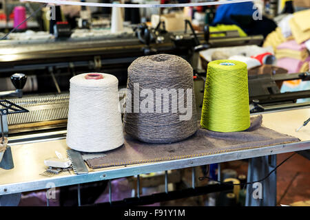 Dettaglio di tre dimensioni industriali rocchetti di filo di cotone in una varietà di colori nella produzione industriale di magazzino Foto Stock