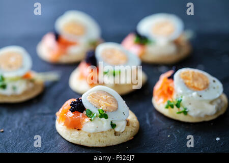 Parte cibo, blinis con salmone, uova di quaglia e caviale Foto Stock