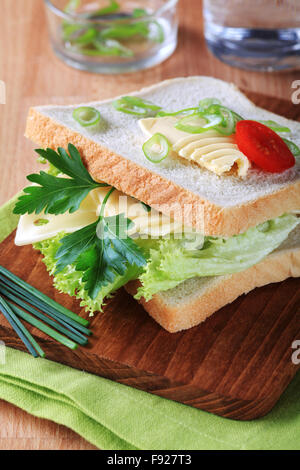 Formaggio e sandwich di lattuga su un tagliere Foto Stock