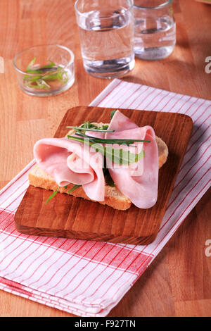 Aprire di fronte panino di prosciutto con verdi ed erba cipollina Foto Stock