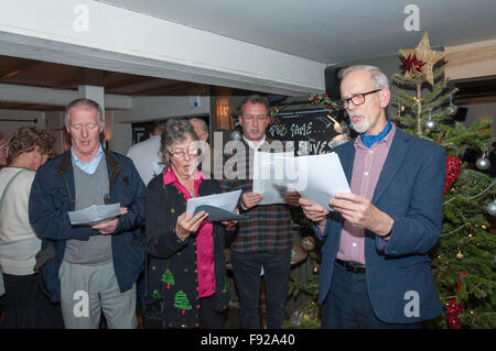 Coro per adulti a cantare i canti natalizi in Il Cricketers Pub, Winkfield fila, Berkshire, Inghilterra, Regno Unito Foto Stock