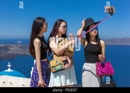 Selfie di Santorini, tre donne persone giovani turisti asiatici che scattano un selfie al telefono bastone turisti di Santorini Grecia Foto Stock