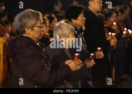 (151213) -- NANJING, Dic 13, 2015 (Xinhua) -- Le persone che frequentano un cero veglia presso il Memorial Hall per le vittime del massacro di Nanjing dagli invasori giapponesi in Nanjing, a est della capitale cinese della provincia dello Jiangsu, a Dic. 13, 2015, la Cina la seconda National Memorial Day per il massacro di Nanjing vittime. (Xinhua/Ji Chunpeng) Foto Stock