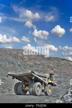 Heavy autocarro con cassone ribaltabile su il minerale di ferro a cielo aperto pronto per essere caricato Foto Stock
