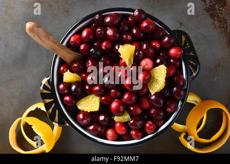 Una pentola piena di mirtilli rossi freschi e pezzi di colore arancione,. Angolo alto vista la tradizionale festa del Ringraziamento piatto laterale. Foto Stock