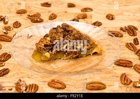 Noci pecan tagliate a fetta di torta con le noci pecan su sfondo di legno Foto Stock