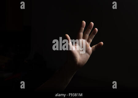 Una mano mans fino contro uno sfondo nero Foto Stock