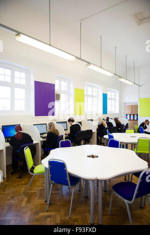 Istruzione secondaria Wales UK: sesta forma gli allievi lavora su computer di stazioni di lavoro nella loro luminosa recentemente ristrutturato camera comune area di studio Foto Stock