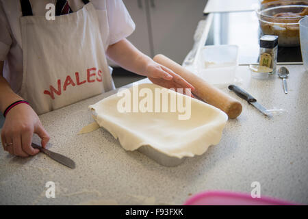 Istruzione secondaria Wales UK: gli alunni la preparazione per la cottura di prodotti alimentari in una tecnologia alimentare (scienze domestiche) Scuola di insegnamento in aula di cucina Foto Stock