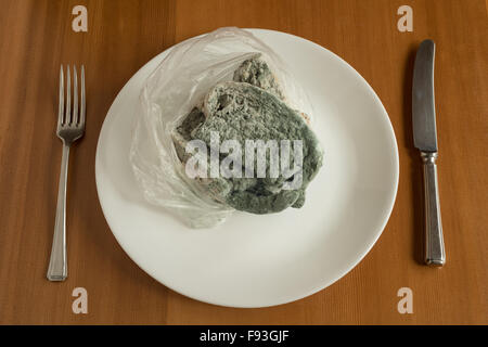 Estremamente stampo ricoperto di formaggio e branston pickle sandwich a sinistra in una busta di plastica piena di funghi e irriconoscibile avvelenamento alimentare Foto Stock