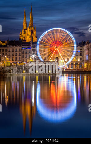 Di notte, una grande ruota (ruota panoramica Ferris) riflettendo in acqua all'Adour e Nive confluenza del fiume (Bayonne - Aquitaine - Francia). Foto Stock