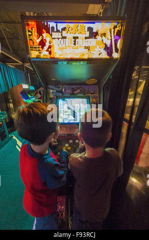 Città Giardino, New York, Stati Uniti d'America. 12 Dic, 2015. L-R, DANIEL TORRES, 5, e NATHANIEL PEREZ, 4, riprodurre il 1988 gioco arcade Double Dragon II: La vendetta, da Technos/Romstar, durante il giorno di apertura di età Arcade presentano in un set di arcade fino alla base del Museo dell'aviazione di Long Island. Ammissione include un numero illimitato di free pay-per-play di video giochi arcade. Presentano corre da Dic. 12, 2015 attraverso Aprile 3, 2016. © Ann Parry/ZUMA filo/Alamy Live News Foto Stock