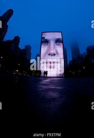 Chicago, Stati Uniti d'America. 12 Dic, 2015. La gente a prendere le foto di Crown Fontana a Chicago, negli Stati Uniti il 12 dicembre, 2015. Il Cloud Gate è artista britannico Anish Kapoor del primo pubblico esterno installato di lavoro negli Stati Uniti. Ispirata dal mercurio liquido, la scultura è tra le più grandi del suo genere in tutto il mondo, misurando 66-piedi lungo da 33-piedi alto, secondo l introduzione della città di Chicago sito ufficiale. © Egli Xianfeng/Xinhua/Alamy Live News Foto Stock