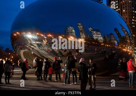 Chicago, Stati Uniti d'America. 12 Dic, 2015. La gente a prendere le foto presso la famosa Cloud Gate in Millennium Park di Chicago, negli Stati Uniti il 12 dicembre, 2015. Il Cloud Gate è artista britannico Anish Kapoor del primo pubblico esterno installato di lavoro negli Stati Uniti. Ispirata dal mercurio liquido, la scultura è tra le più grandi del suo genere in tutto il mondo, misurando 66-piedi lungo da 33-piedi alto, secondo l introduzione della città di Chicago sito ufficiale. © Egli Xianfeng/Xinhua/Alamy Live News Foto Stock