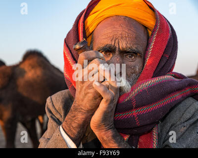 Rajasthani anziani uomo con un turbante fumare una tubazione di hash, Pushkar, Rajasthan, India Foto Stock